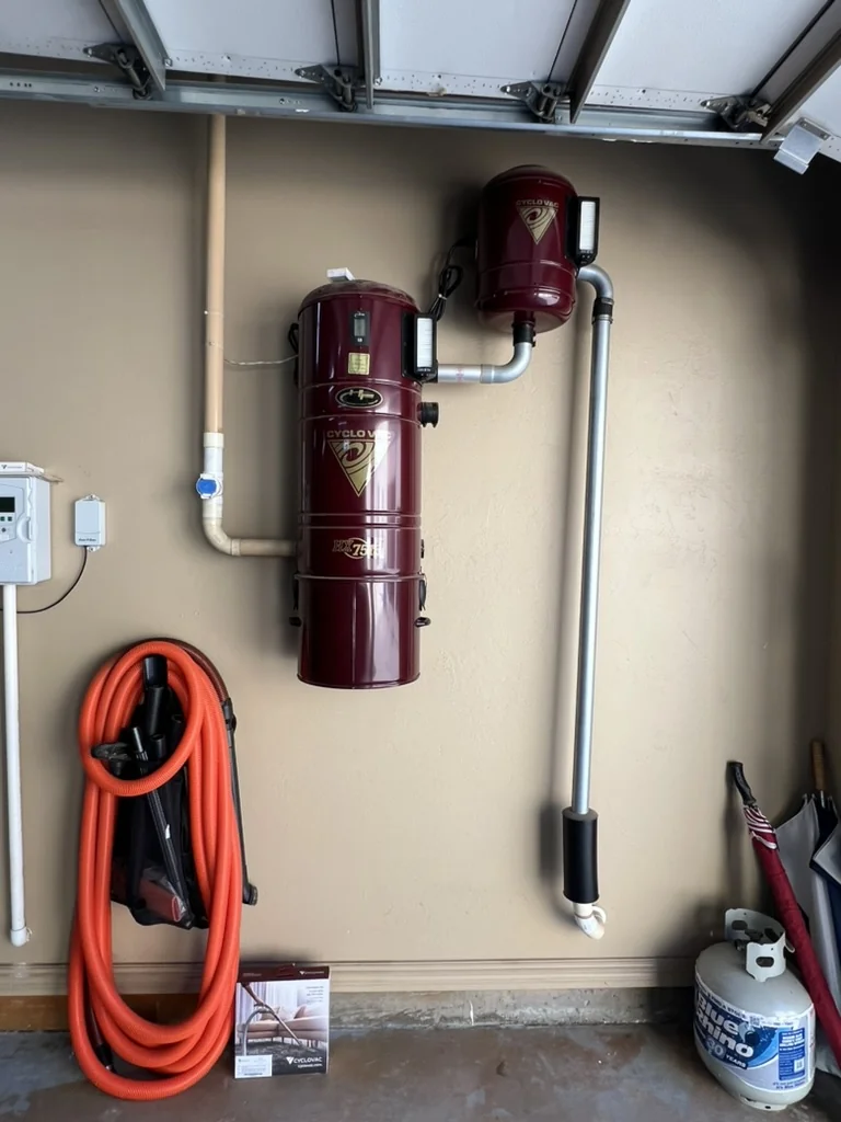 Maroon Cyclo Vac central vacuum system installed in a garage